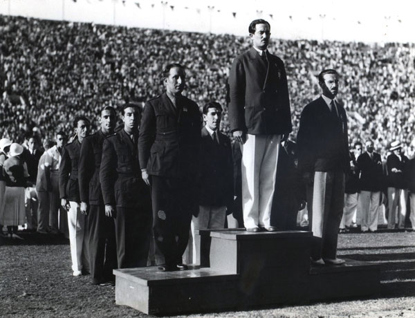 For the first time, medal winners stood on a victory stand and watched the raising of the flag of the winners country.